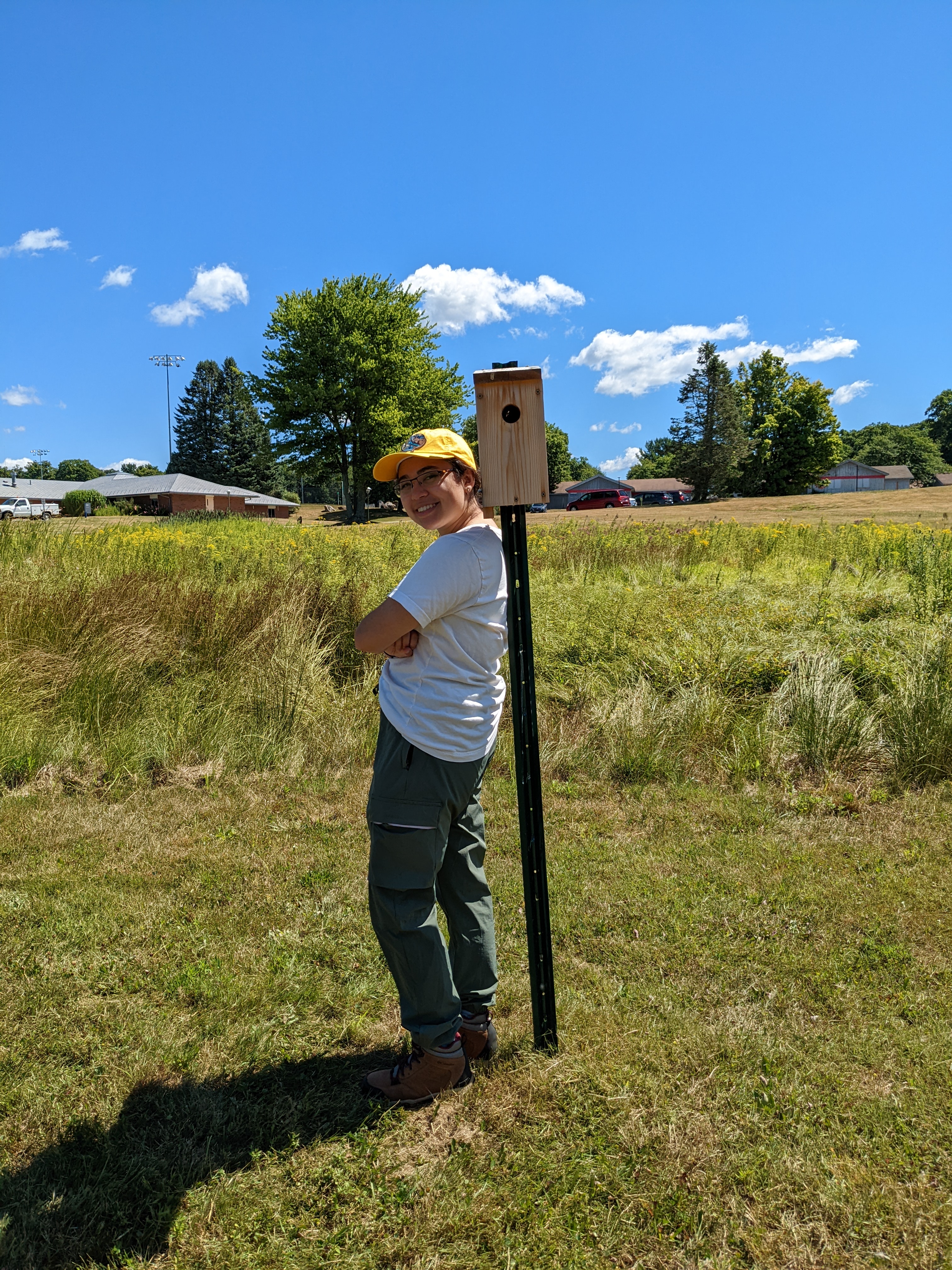 Photograph of a person standing with their back to a nest box.